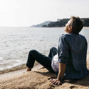 Spain, Girona, Lloret de Mar. 50-year-old man walking and enjoying an afternoon on the beach